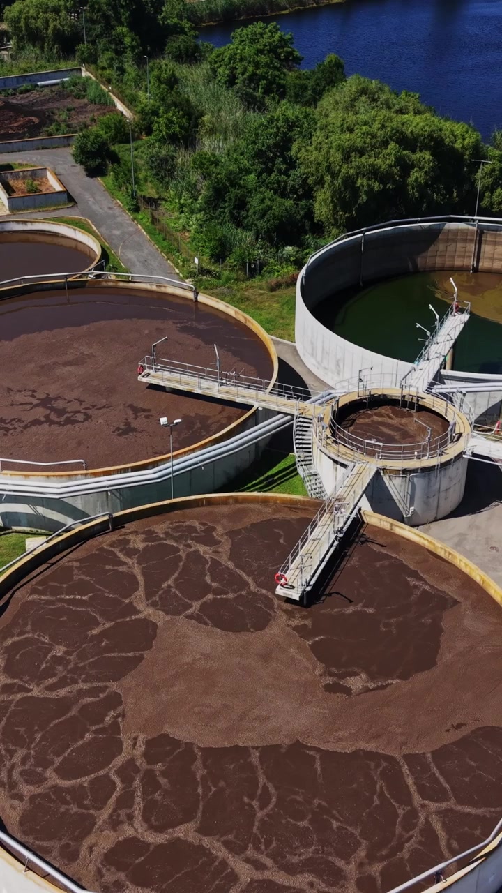Planta de tratamiento de agua en funcionamiento cerca de un río en un día soleado.