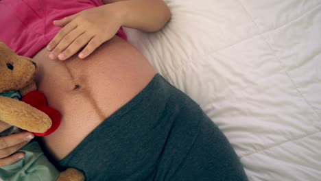 happy pregnant woman sleeping on bed in bedroom.