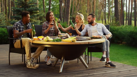 gente alegre hablando afuera. gente positiva haciendo sonar copas en una fiesta de barbacoa.