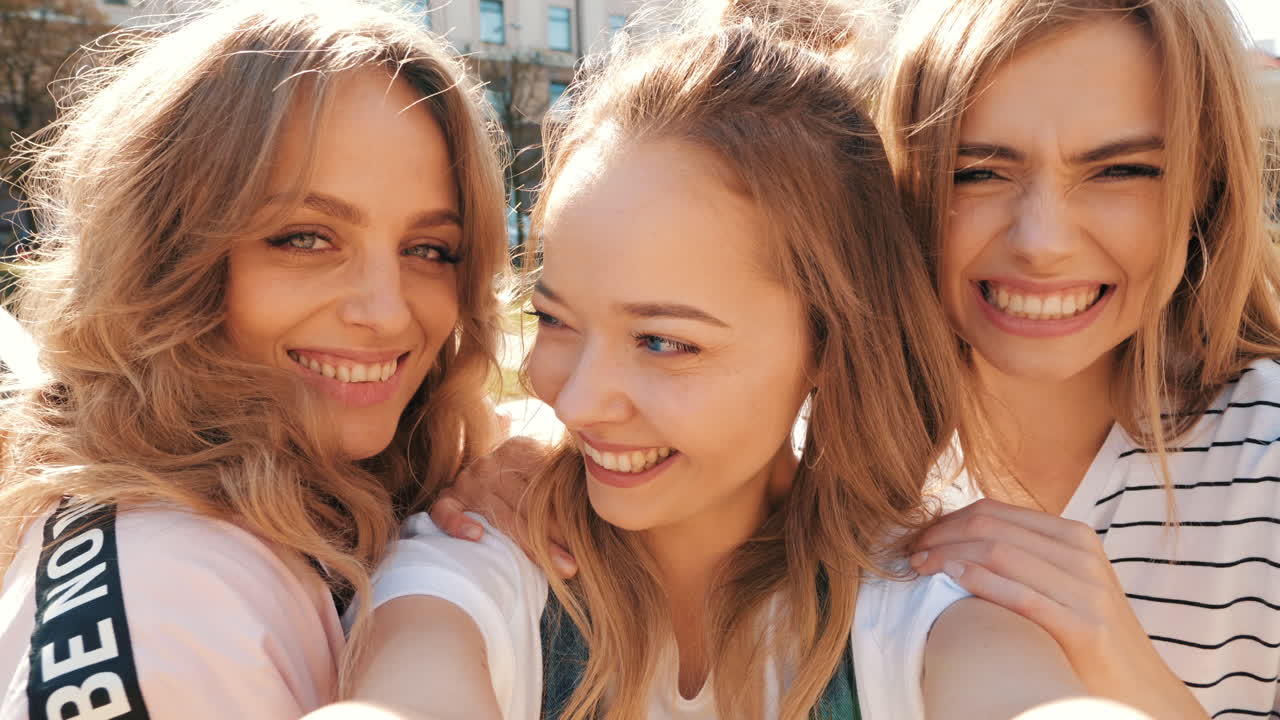 tres mujeres jóvenes tomando una selfie al aire libre en la ciudad
