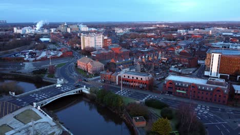 Aerial-early-morning-city-street-traffic-commuting-intersection-lanes-crossing-curved-river-slow-orbit-right