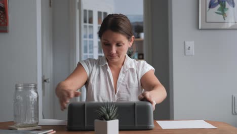 Wide-shot-caucasian-woman-closing-portable-typewriter