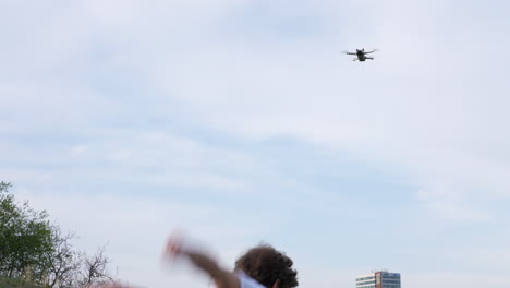 young man doing somersault backward flip under drone flying above, slow motion