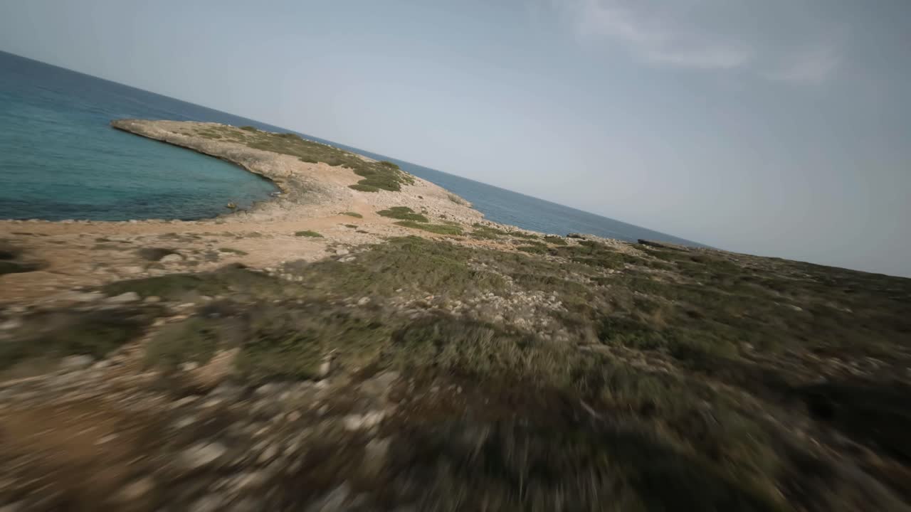 저녁 시간 동안 스페인 마요르카 칼라 바케스에 정박한 범선과 함께 해변을 따라 가파른 절벽의 fpv 드론 타임랩스 샷