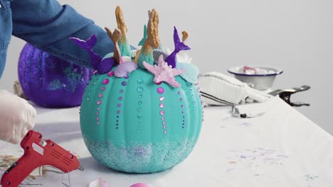 mother and daughter decorating art pumpkins