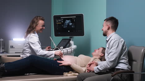 pregnant woman lying on a stretcher in the medical consultation with her husband