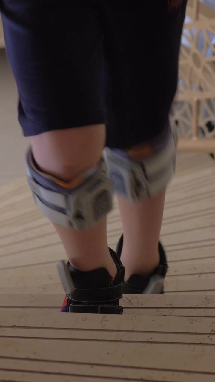 Child with foot drop system walking upstairs. FES therapy