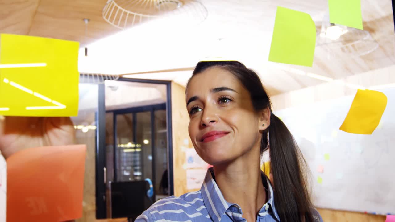 ejecutivo de negocios pegando una nota adhesiva en el vidrio