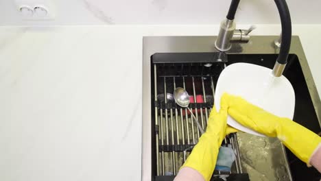 persona lavando platos en un fregadero de la cocina