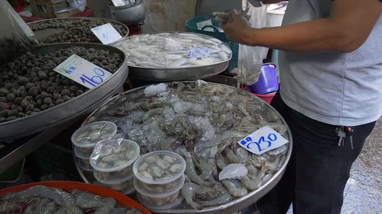 cliente comprando camarones de río camarón en el mercado de pescado de la calle comida asiática tailandia