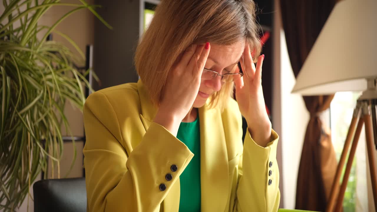 mujer con dolor de cabeza en la oficina