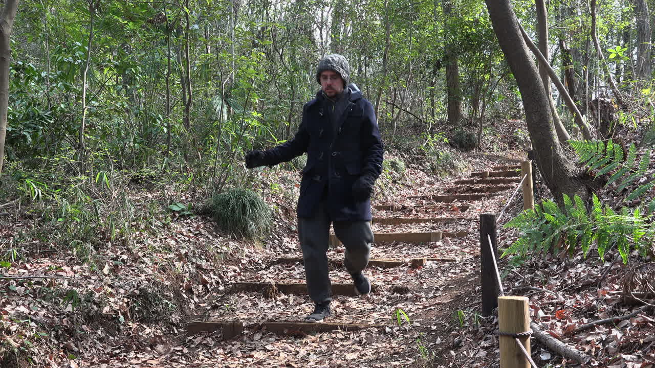 백인 남자가 낮에 황량한 공원의 계단을 내려가고 있다