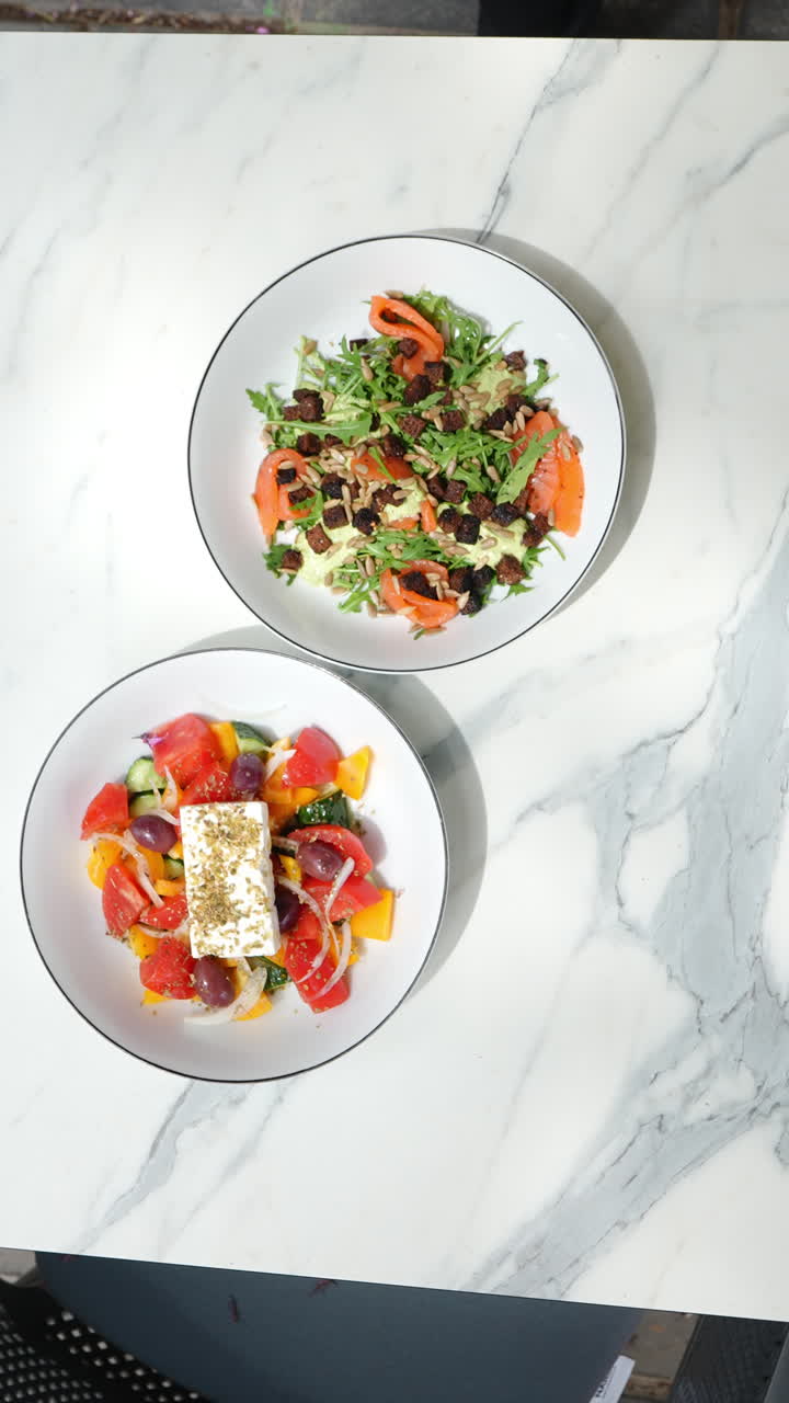 Vertical footage Professional chef preparing vibrant salad garnish on white plates
