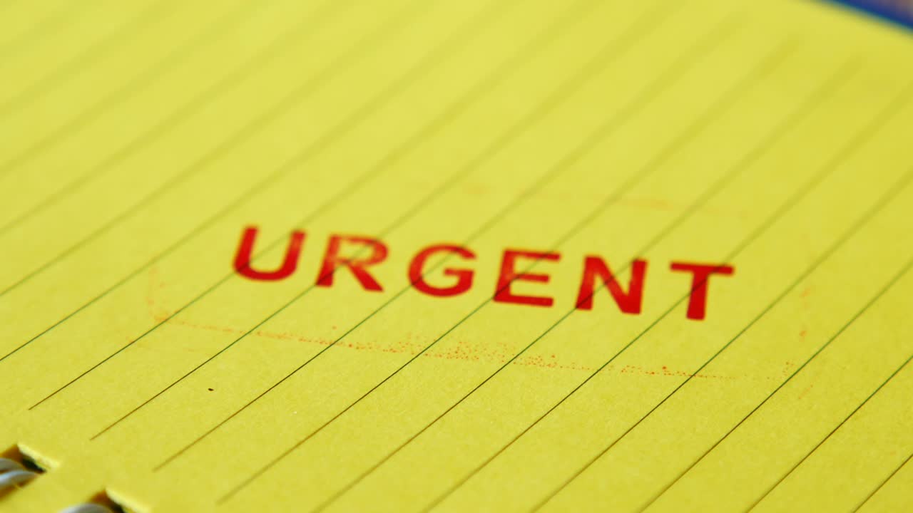 Urgent Stamp on Yellow Notepad