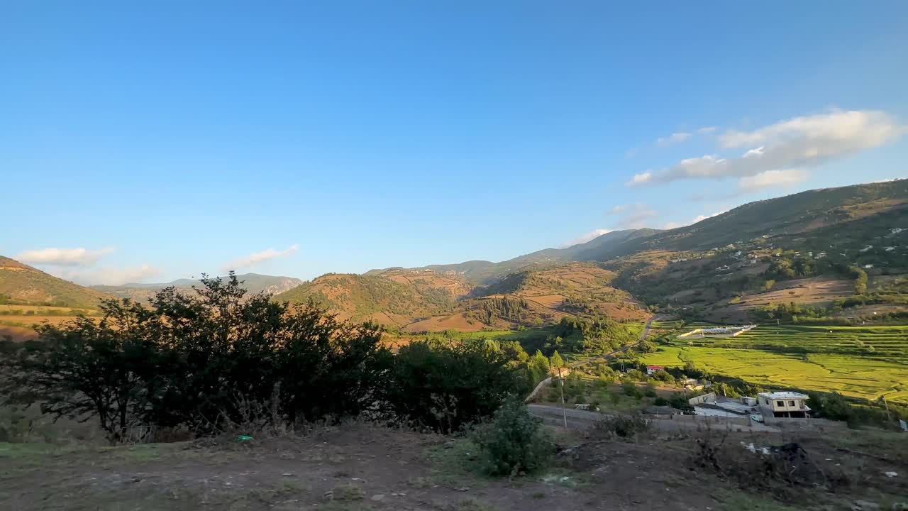 Nature of rice paddy farm in Plain in a sunny day golden sunset time panoramic scenic wide view of rural area village town countryside green hills forest mountain climate in Gilan Iran nomad farmer