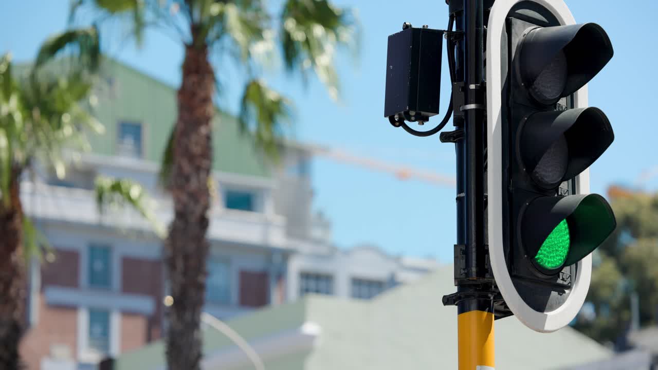 Semáforo en poste amarillo cambiando de rojo a verde, manteniéndose en verde, dejando pasar coches, espacio para texto