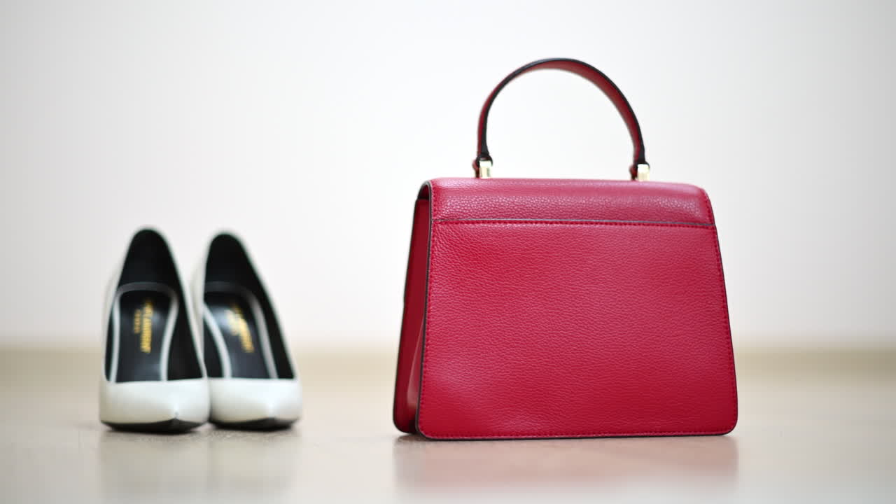 Close up of white woman shoes and red purse