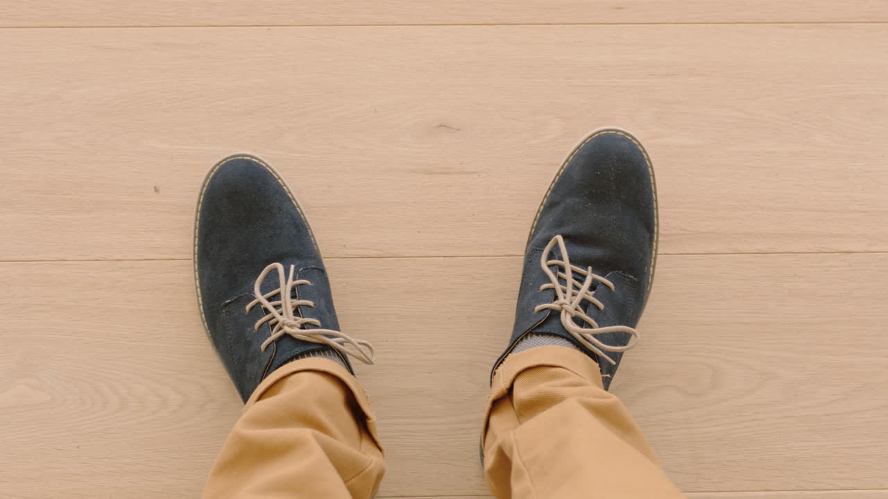 나무 바닥 에 서 있는 세련 된 신발 을 즐기는 신발 을 입은 남자