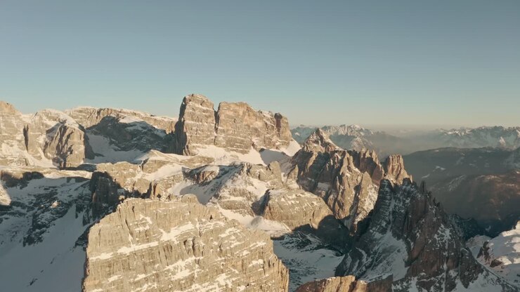 Ripresa drone in avanti sopra cime montuose frastagliate nelle Dolomiti, Italia