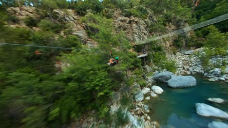 active woman traveller zip lining through green forest and mountain river