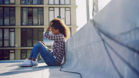 Fashionable-young-woman-on-urban-rooftop-using-smartphone