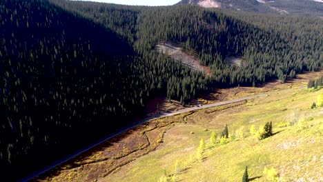 A-road-at-the-bottom-of-an-aspen-and-pine-valley