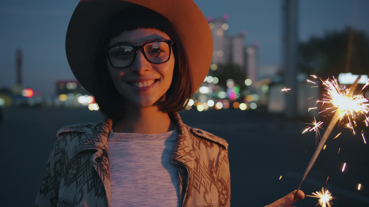 Woman with sparklers in the city at night