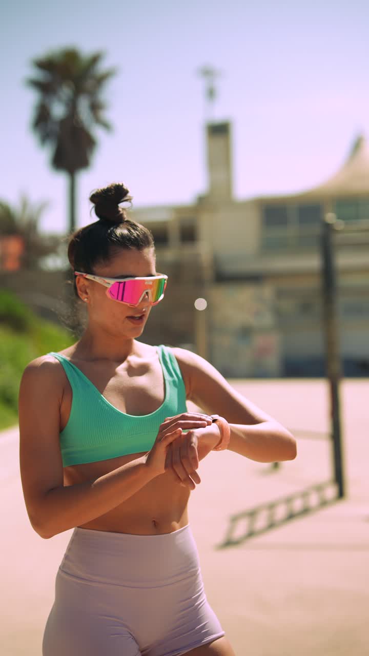 Young Woman in Sportswear Checking Smartwatch Outdoors
