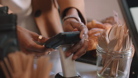 close up customer using credit card machine typing password making payment at restaurant cafe