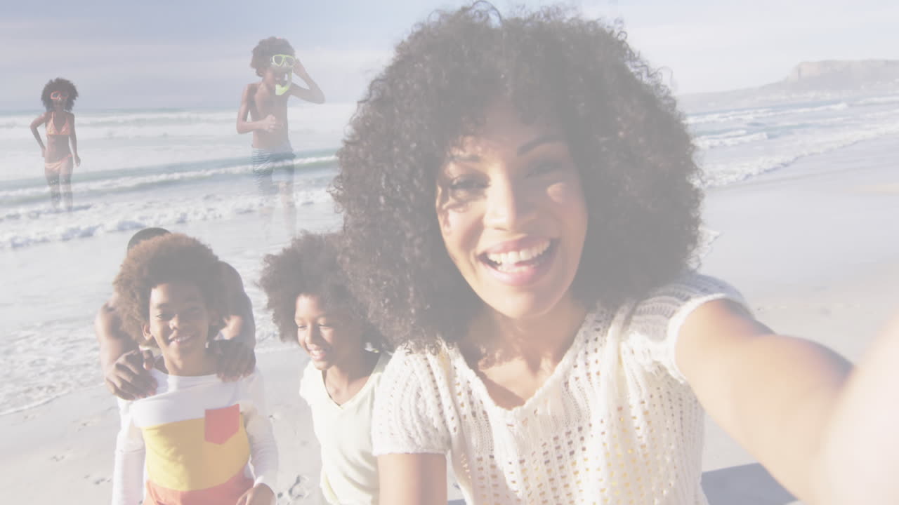 compuesto de una feliz familia afroamericana tomando selfies y corriendo por la playa.