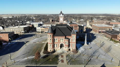 aerial drone video orbiting around a red brick historic building in the town square