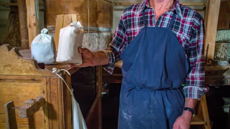 grain farmer passes a bag of his product to a customer who has just purchased it