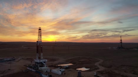 Oil-and-gas-drilling-rig-onshore-dessert-drone-view-sunset