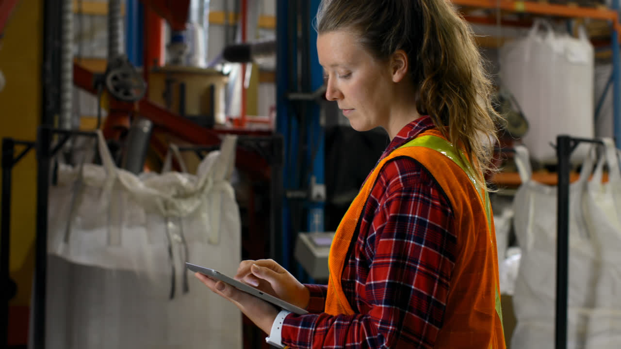 Side view of caucasian female worker working on digital tablet in warehouse 4k
