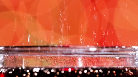 Glass-of-cola.-Ice-cola-with-splashing-bubbles-slow-motion-on-a-blurry-light-,blurry-background.