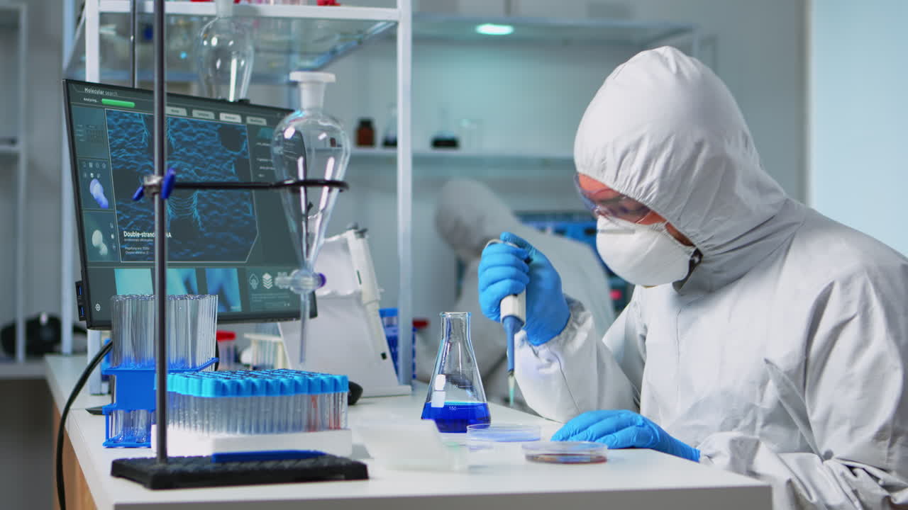 químico en traje de ppe utilizando una micropipeta para llenar tubos de ensayo