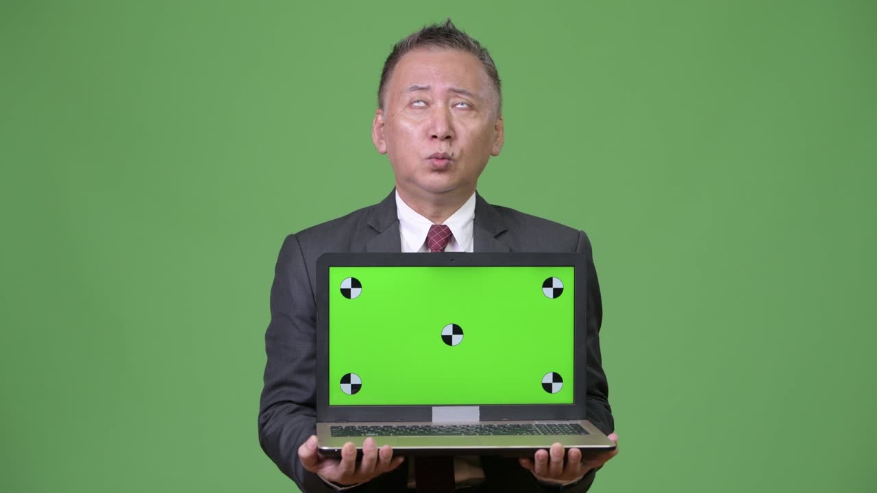 Pengusaha Jepang paruh baya menunjukkan laptop