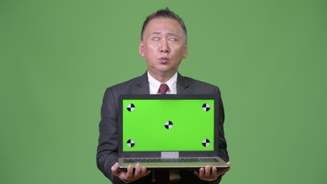 mature japanese businessman showing laptop