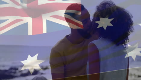 animation of flag of australia over african american couple kissing on beach