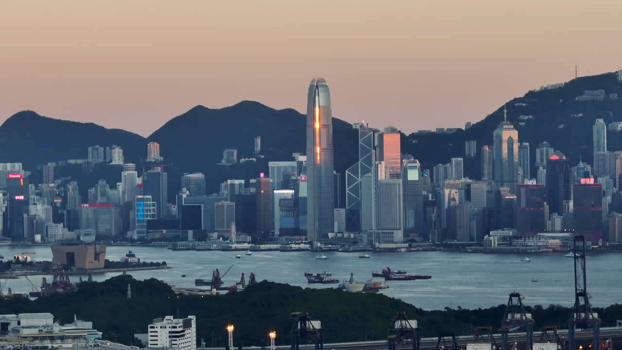 plano general aéreo que muestra la ciudad central de hong kong con el horizonte y las montañas de fondo al atardecer