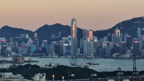 Plano-General-Aéreo-Que-Muestra-La-Ciudad-Central-De-Hong-Kong-Con-El-Horizonte-Y-Las-Montañas-De-Fondo-Al-Atardecer