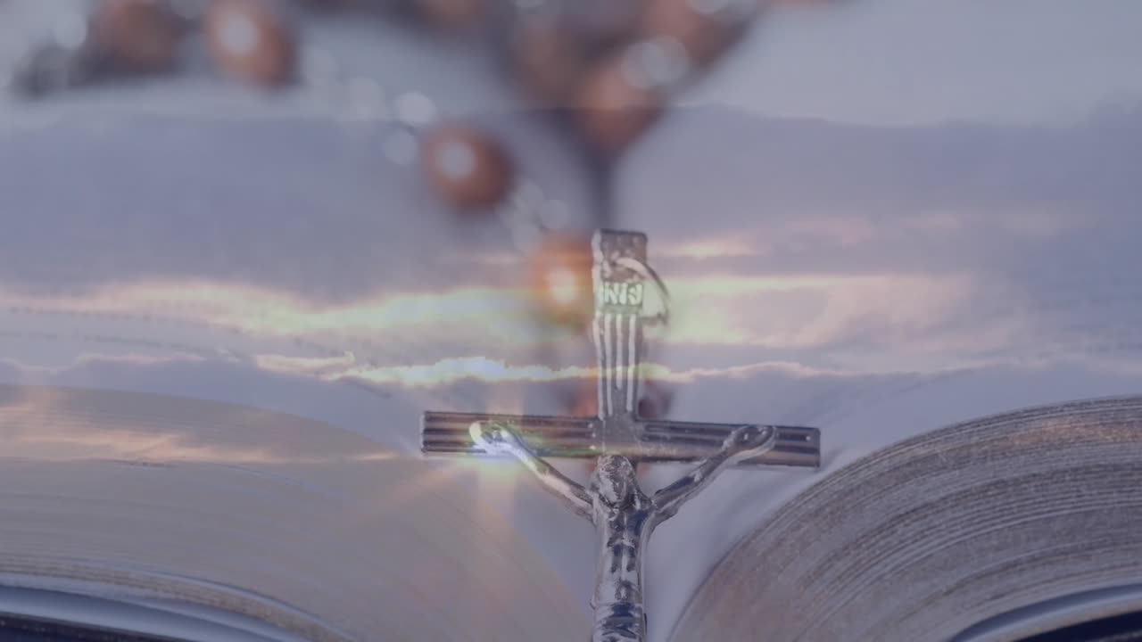 Bible open with crucifix and rosary beads, gentle light creating serene animation