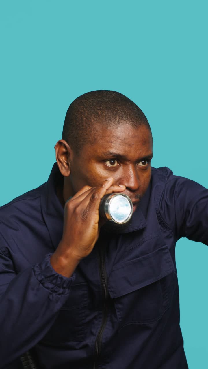 African Man Cautiously Searching with a Flashlight