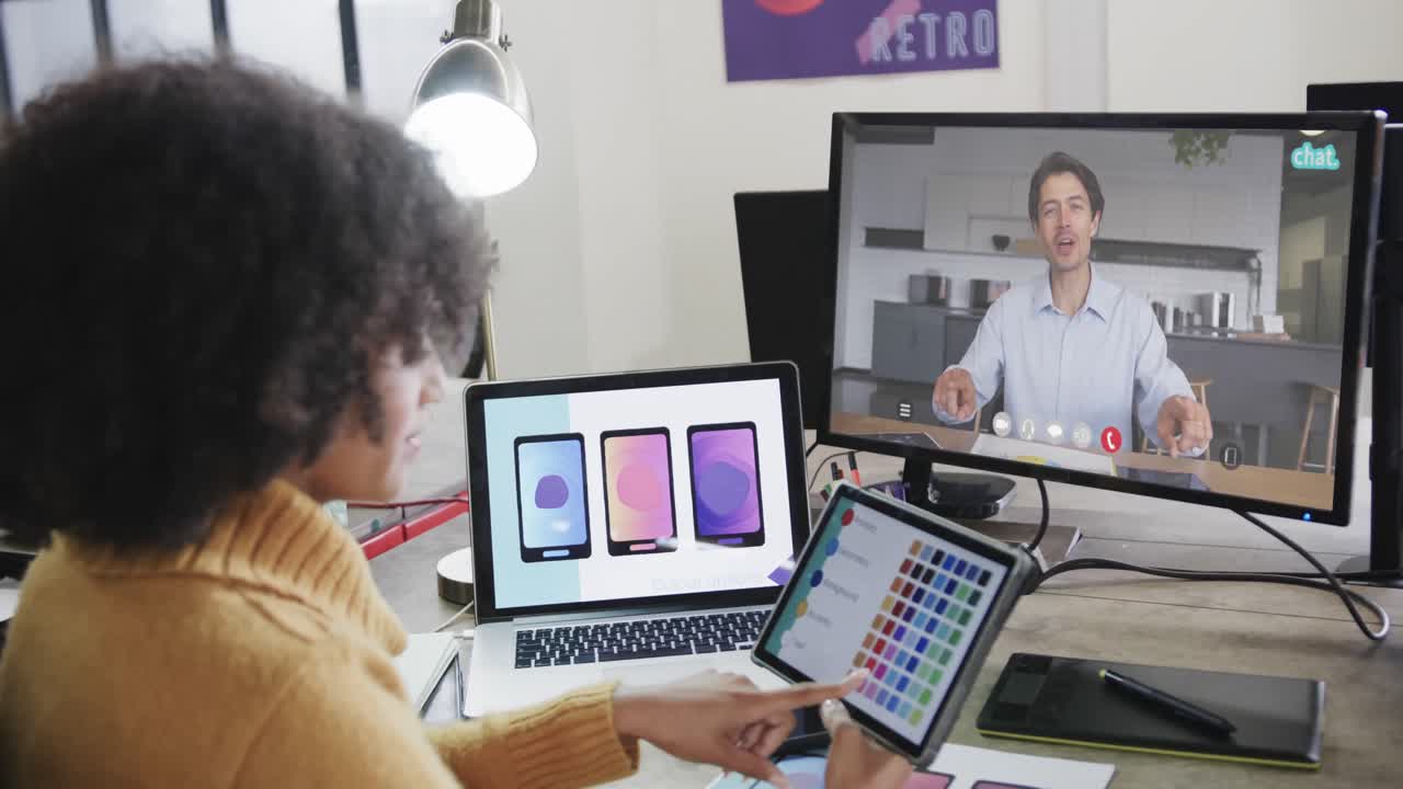 mujer de negocios afroamericana en videollamada con un colega caucásico en la pantalla