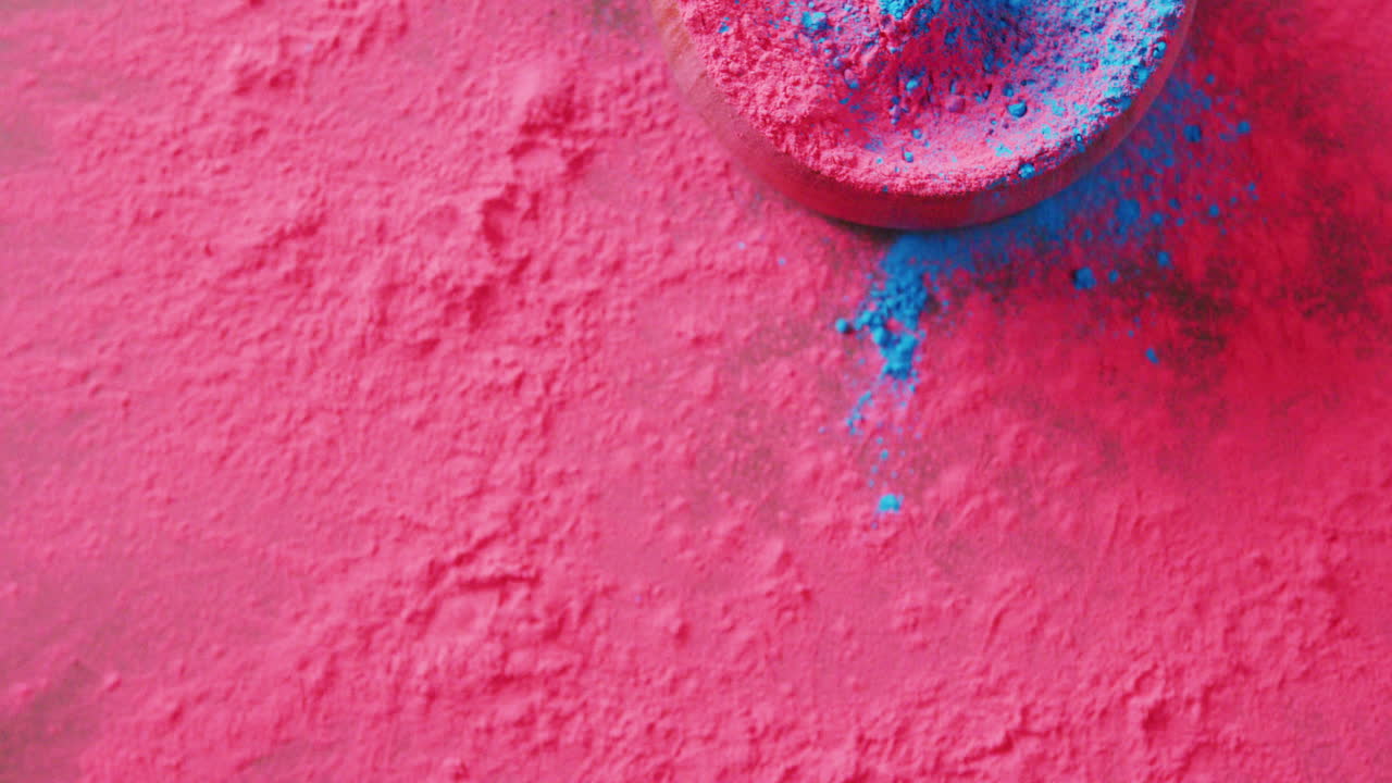 Video di polveri colorate rosa e blu e ciotola con spazio per il testo su sfondo nero.