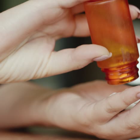 mujer vierte pastillas en su palma