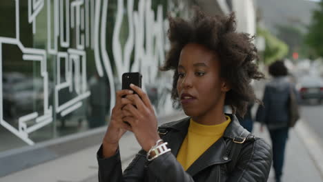 Porträt-Einer-Stilvollen-Afroamerikanischen-Frau,-Die-Ihr-Smartphone-Nutzt-Und-Mit-Der-Handykamera-Technologie-In-Der-Stadtstraße-Fotografiert