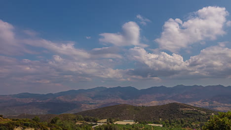 el lapso de tiempo de las nubes que se mueven hacia la cordillera del horizonte en el fondo