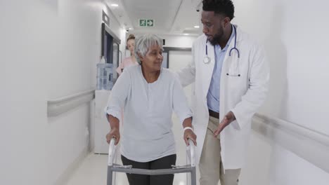 diversos médicos hombres y mujeres felices hablando con una paciente anciana en el pasillo, en cámara lenta.