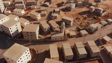 aerial shot of an old empty city in the desert in palestine near gaza while camera moves closer to the buildings revealing the horizon